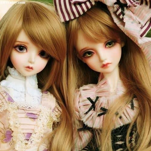 two dolls are sitting next to each other dolls 