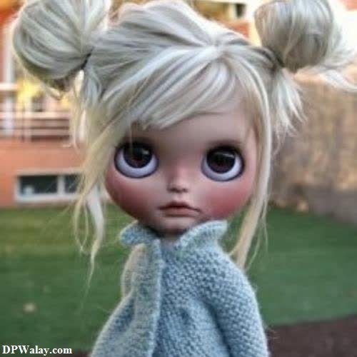 a doll with blonde hair and a blue sweater