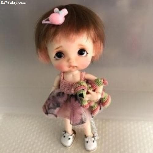 a doll with a pink dress and a pink bow