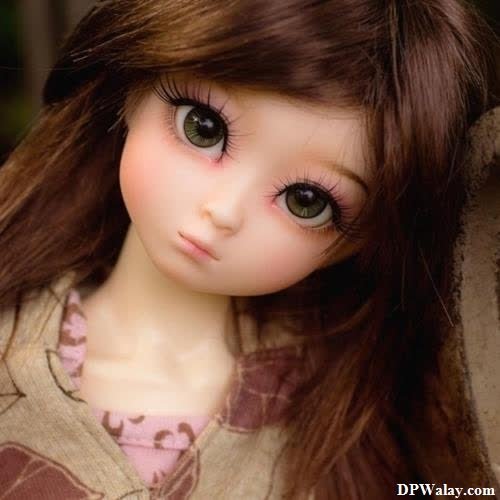 a doll with long brown hair and a brown dress