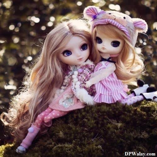 barbie doll DP - two dolls sitting on top of a moss covered rock