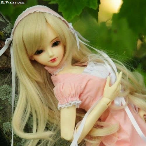 a doll sitting on top of a tree branch 