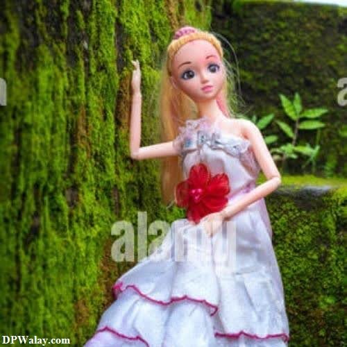 a doll is standing on a moss covered wall barbie photos dp 