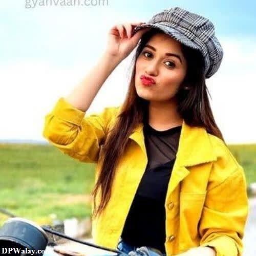 a woman in a yellow jacket and hat sitting on a motorcycle images by DPwalay
