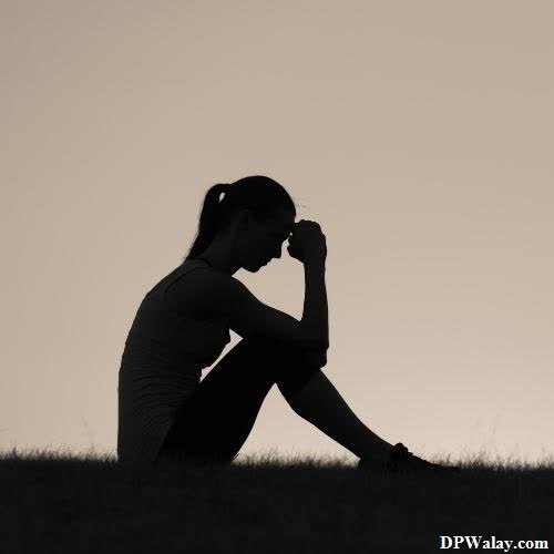 sad girl dp - a woman sitting on the grass with her head in her hands