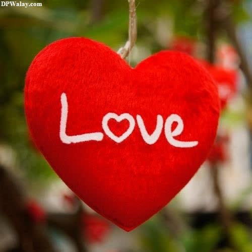 a red heart hanging from a tree with the word love written on it best love dp for instagram