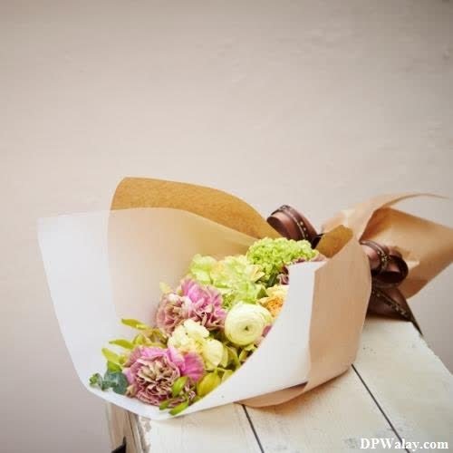 a bouquet of flowers on a wooden table best unique dp for whatsapp