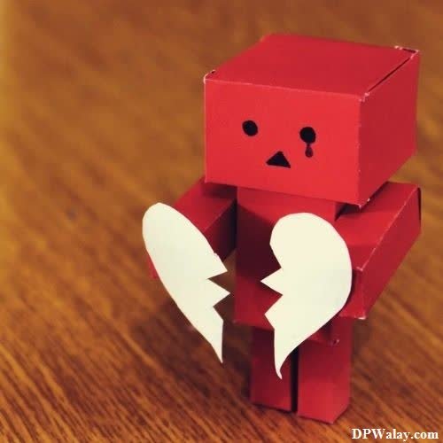 breakup dp - a red paper toy with a broken heart