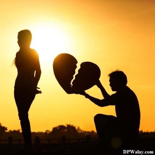 breakup dp - silhouette of a couple holding hands at sunset