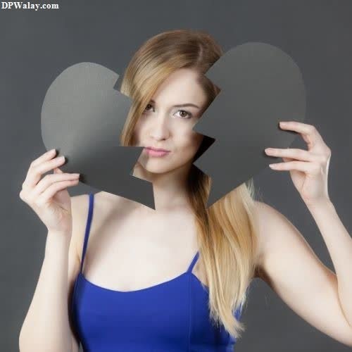 a woman holding a heart shaped mirror