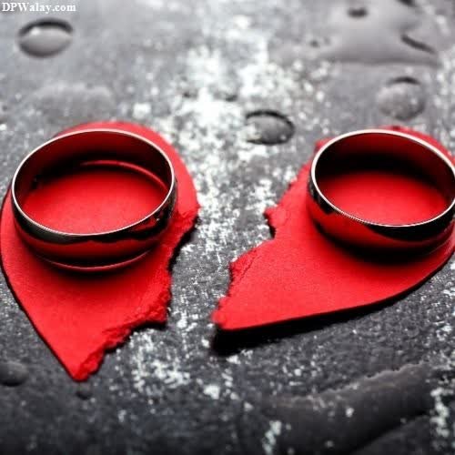 two wedding rings on a piece of red paper