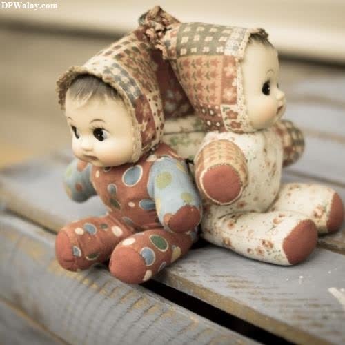 a small doll sitting on top of a wooden bench