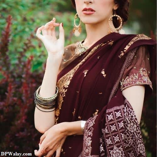 hidden face dp for girls - a woman in a maroon sari with gold jewelry