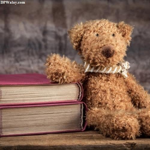 a teddy bear sitting on top of a book
