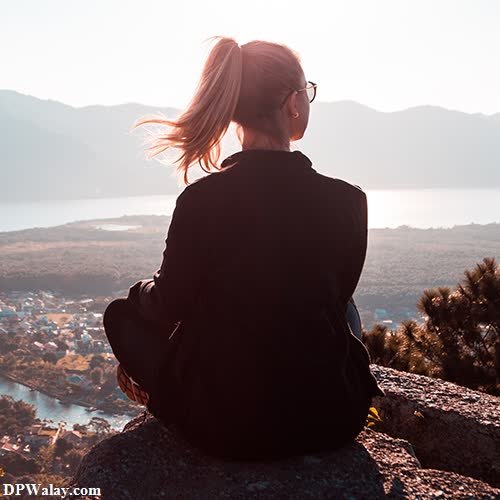 cute dp - a woman sitting on top of a mountain looking out over a lake