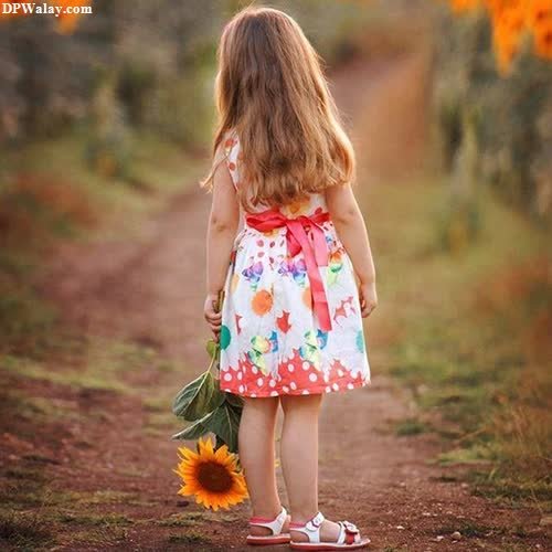 a little girl in a dress and sunflowers 
