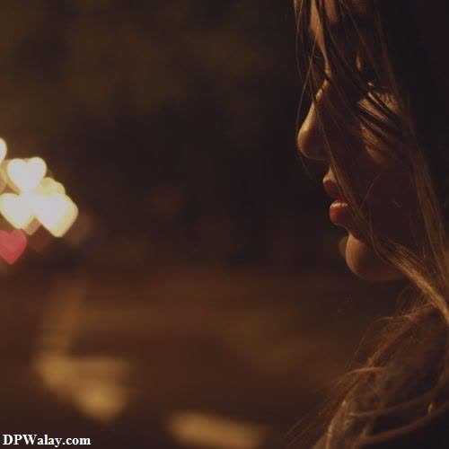 a woman with long hair and a red lipstick looks at the street lights