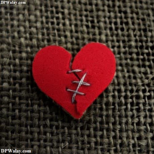 a red heart with a silver cross on it