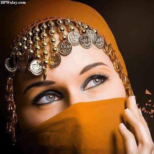 hidden face dp for girls - a woman wearing a head scarf and a gold headpiece