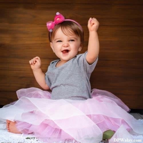a little girl sitting on a bed with her hands up dp images cute 