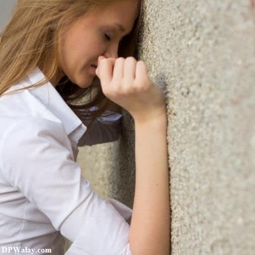 a little girl leaning against a wall