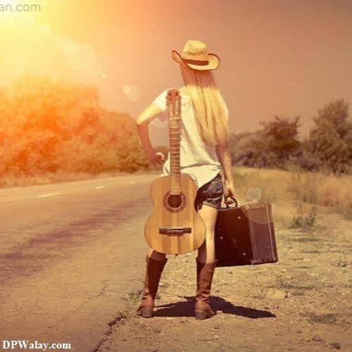 a woman with a guitar and suitcase standing on the road dp ke liye picture