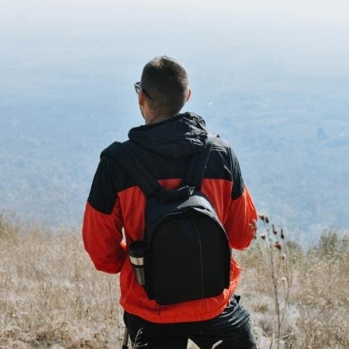 dp pic - a man with a backpack is standing on a mountain
