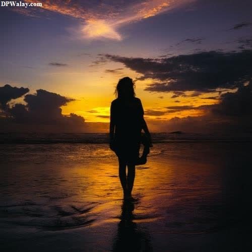 a woman walking on the beach at sunset-KDot