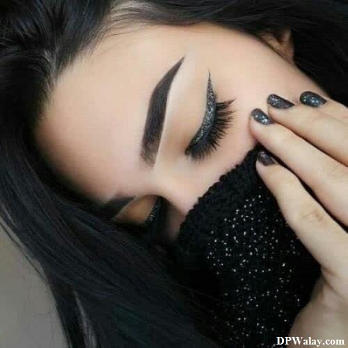 a woman with long black hair and black nails 