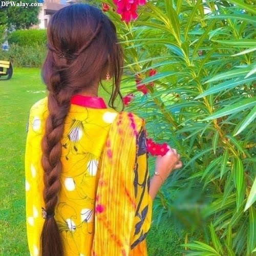 a girl with long hair standing in front of a bush images by DPwalay