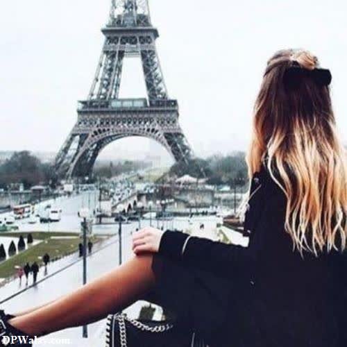 a woman standing in front of the eiff tower face hide dp