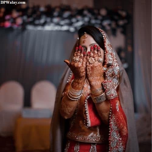 a bride in a red and white outfit is praying