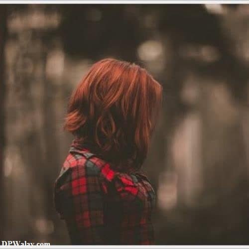 a woman with red hair and a plaid shirt 