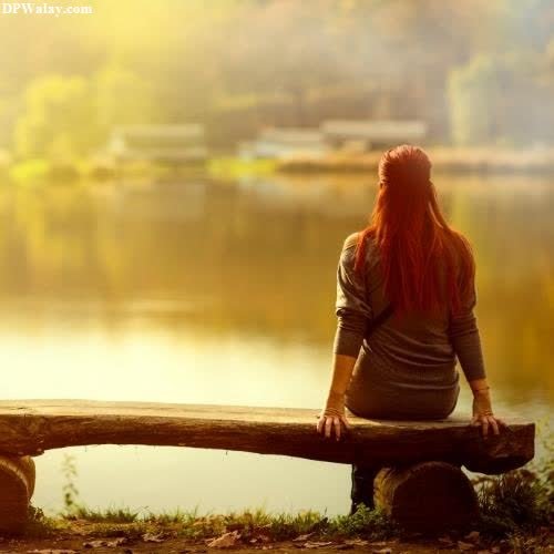girls dp - a woman sitting on a bench looking out over a lake