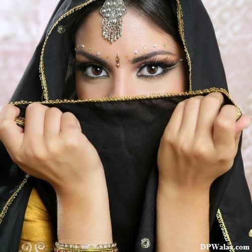 a woman in a black veil with gold jewelry