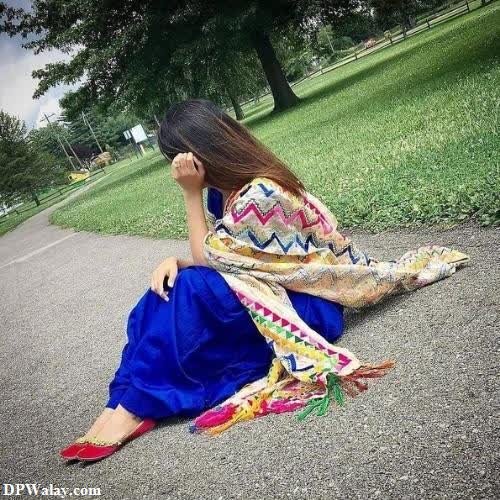 a woman sitting on the ground in a park girls dp photo 