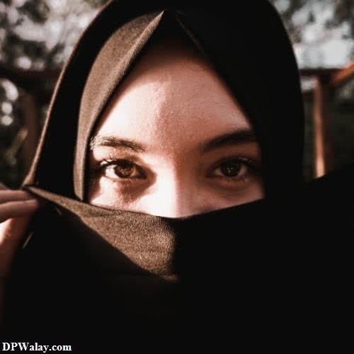 a woman in a black hoodie is looking into the camera 