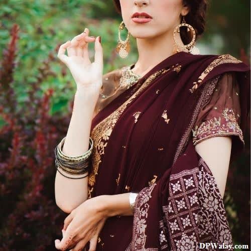 a woman in a maroon sari with gold jewelry images by DPwalay