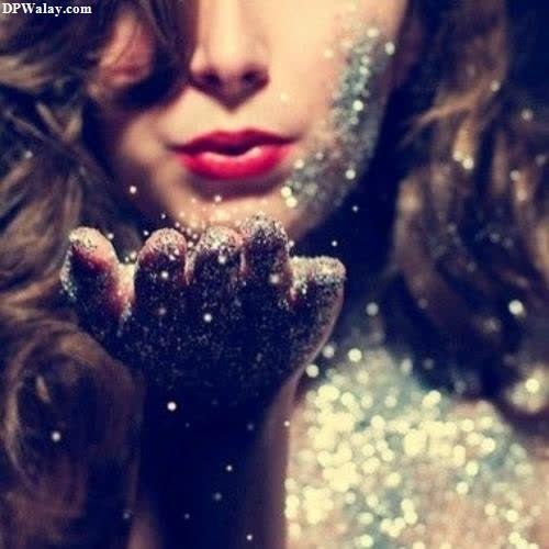 a woman with glitter on her face and hands