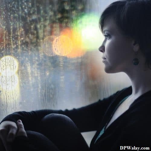 girls dp - a woman looking out the window at the rain
