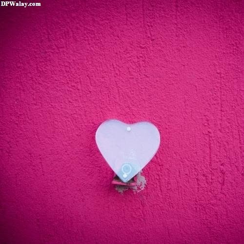 a heart shaped object on a pink wall 