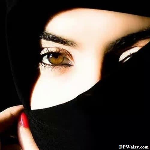a woman wearing a black veil and red nails