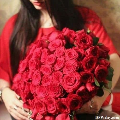 a woman holding a bouquet of red roses images by DPwalay