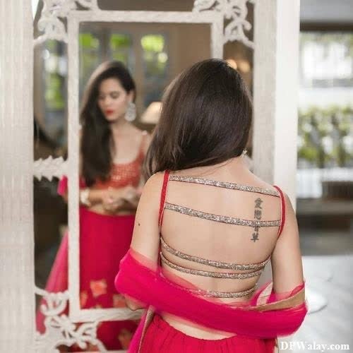 a woman in a red dress looking at herself