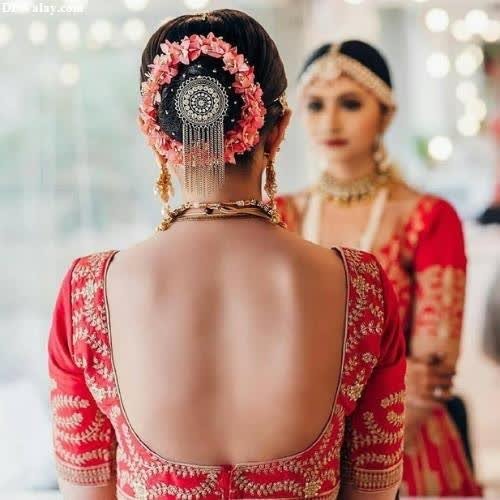 a bride in a red sari with a flower in her hair images by DPwalay