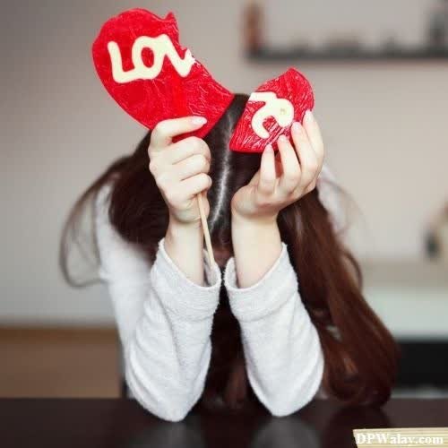 a girl holding up two red hearts i hate love dp download