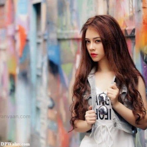 girls dp - a woman standing in front of a wall with graffiti