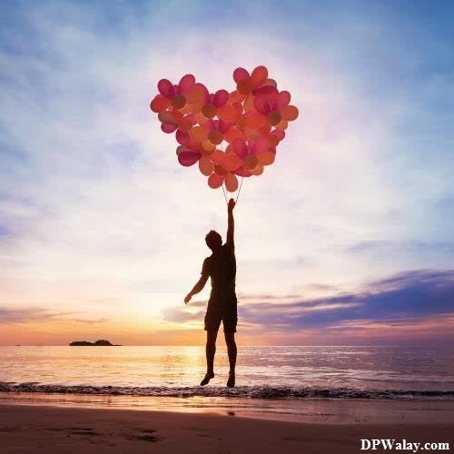a person holding balloons on the beach insta dp love 