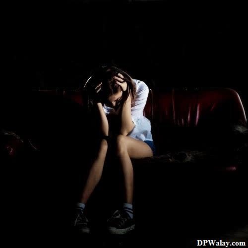 a woman sitting on a couch in the dark insta dp sad
