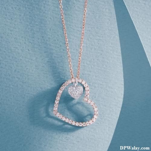 a heart shaped pendant with diamonds on a blue background